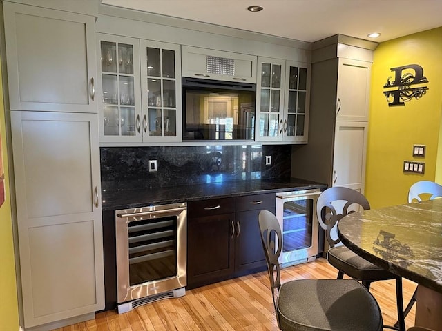 bar featuring wine cooler, tasteful backsplash, light wood finished floors, and recessed lighting