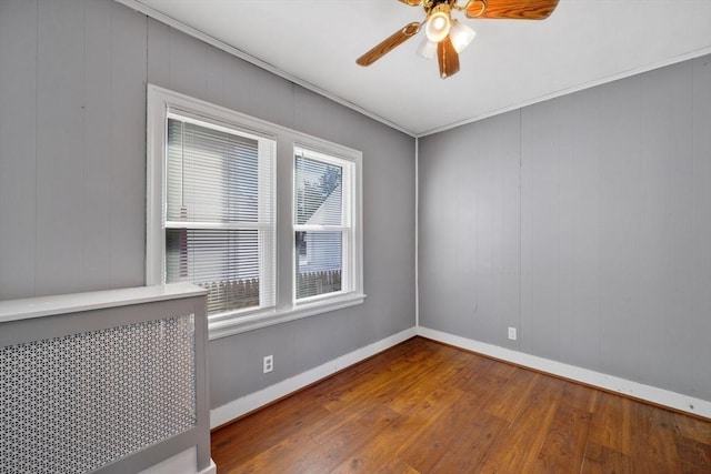 spare room with hardwood / wood-style flooring, ceiling fan, and ornamental molding