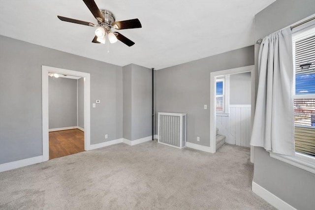 carpeted spare room featuring ceiling fan