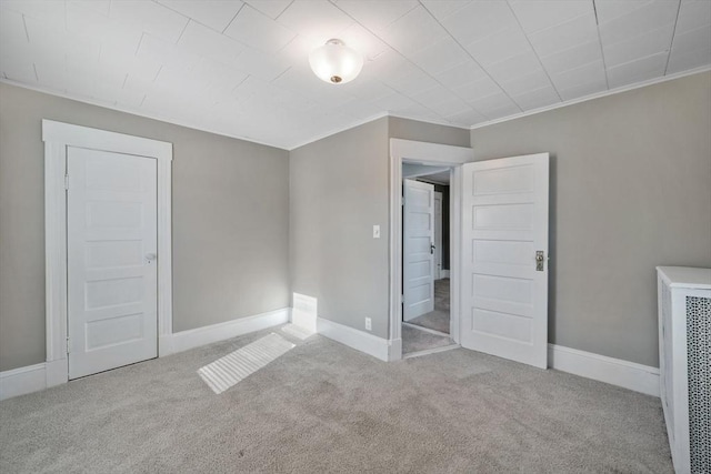 unfurnished bedroom with crown molding and light colored carpet