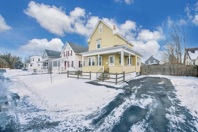 snow covered house featuring a porch