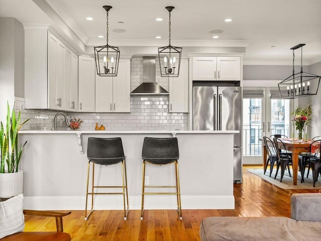 49 Coffey St Unit B, Boston, MA 02122 - kitchen featuring wall chimney range hood, high end refrigerator, a kitchen breakfast bar, light countertops, and decorative light fixtures