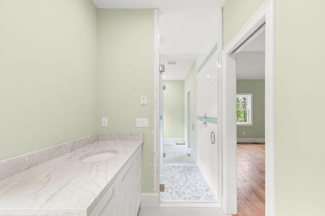 unfurnished bedroom featuring ensuite bathroom, ceiling fan, light hardwood / wood-style floors, and high vaulted ceiling