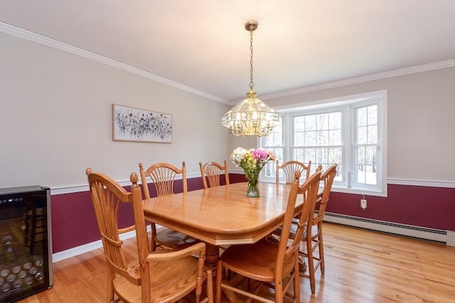 dining space featuring crown molding, light hardwood / wood-style flooring, a notable chandelier, beverage cooler, and a baseboard heating unit