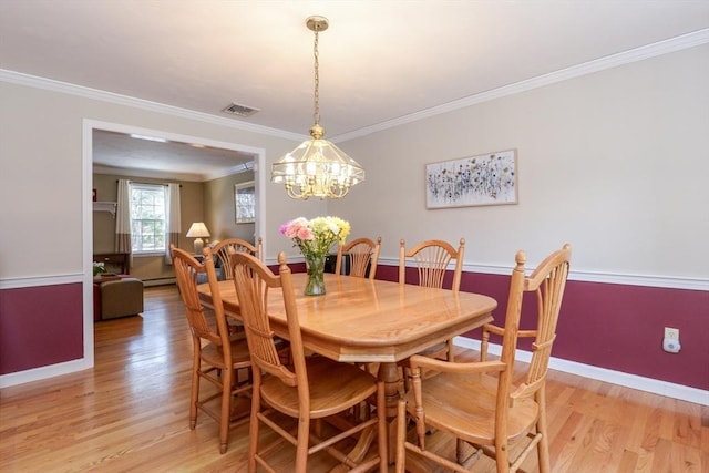 dining space featuring crown molding, light hardwood / wood-style floors, and a notable chandelier