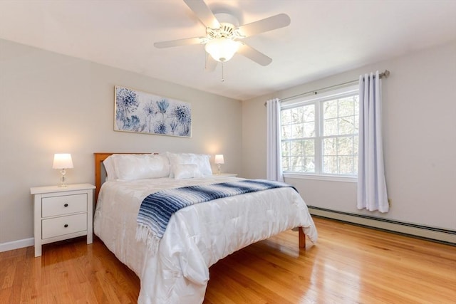 bedroom with a baseboard radiator, light hardwood / wood-style floors, and ceiling fan