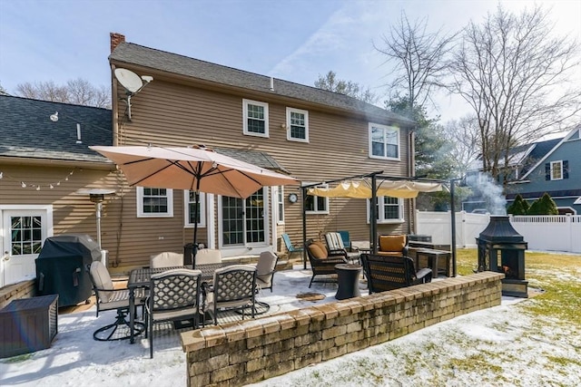 snow covered house featuring a patio