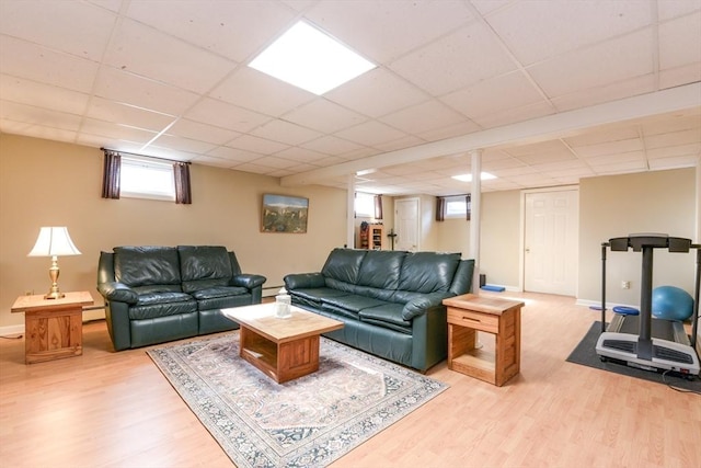 living room with a baseboard radiator, a paneled ceiling, and light wood-type flooring