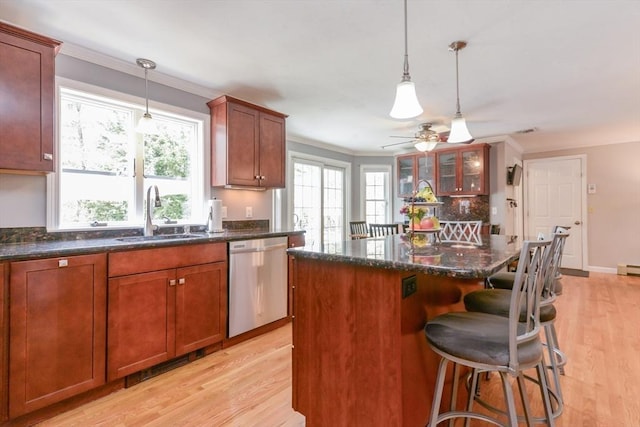 kitchen featuring dishwasher, a center island, sink, and light wood-type flooring