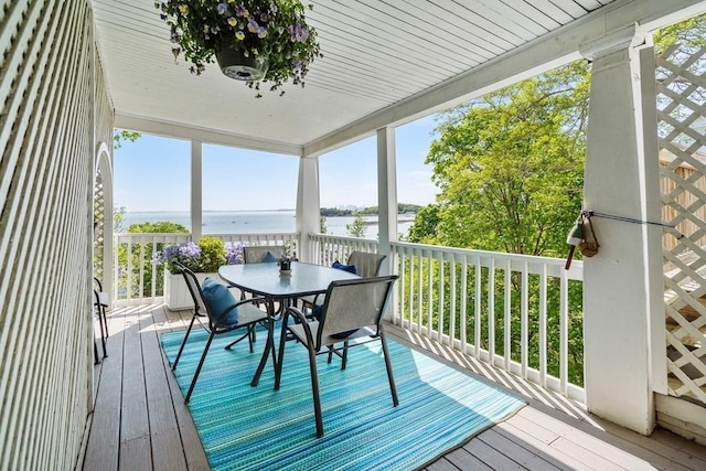 wooden deck with outdoor dining space and a water view