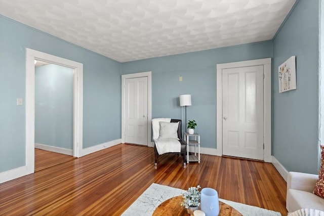 sitting room with baseboards and wood finished floors