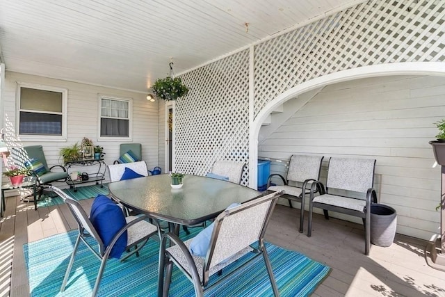 view of patio with a wooden deck and outdoor dining area