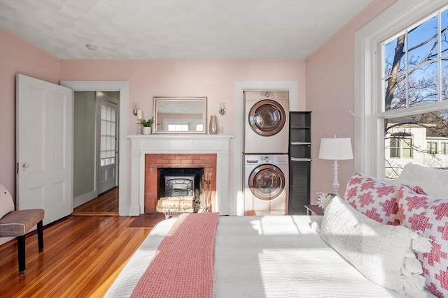 living room featuring a wealth of natural light, wood finished floors, and stacked washer / dryer