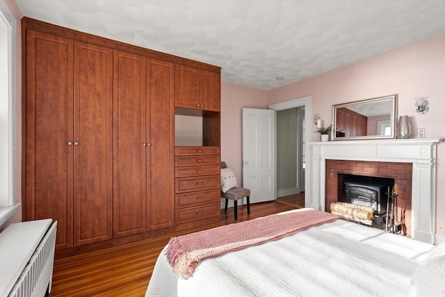 bedroom featuring radiator and wood finished floors