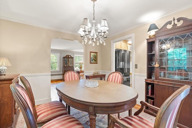 3 Marshall St, North Reading, MA 01864 - dining room featuring radiator heating unit, arched walkways, a chandelier, a wainscoted wall, and crown molding