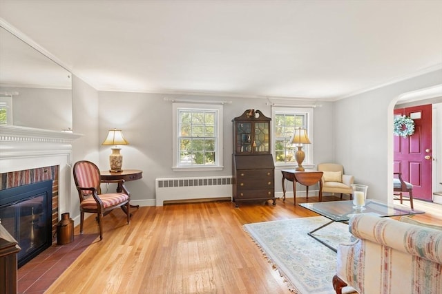 3 Marshall St, North Reading, MA 01864 - living room featuring radiator heating unit, arched walkways, a fireplace, hardwood / wood-style floors, and ornamental molding