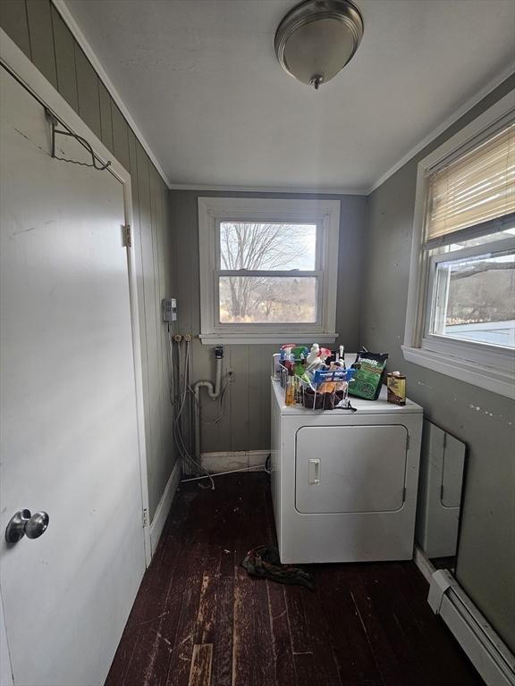 laundry room with baseboard heating, dark hardwood / wood-style flooring, ornamental molding, and washer and dryer