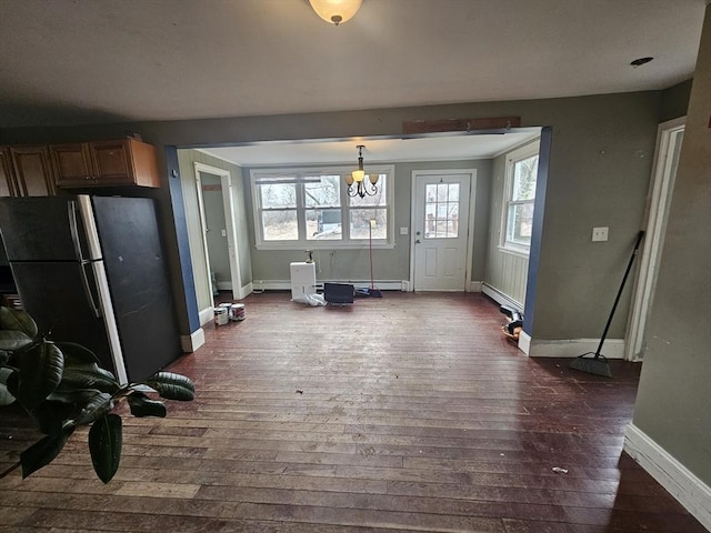 interior space featuring dark wood-type flooring, a chandelier, and a baseboard radiator