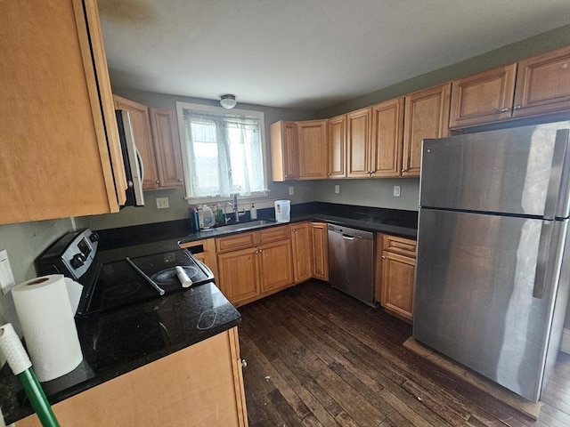 kitchen with dark wood-type flooring, appliances with stainless steel finishes, and sink