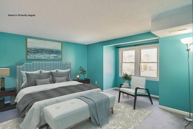 bedroom featuring visible vents, baseboards, carpet floors, and a textured ceiling