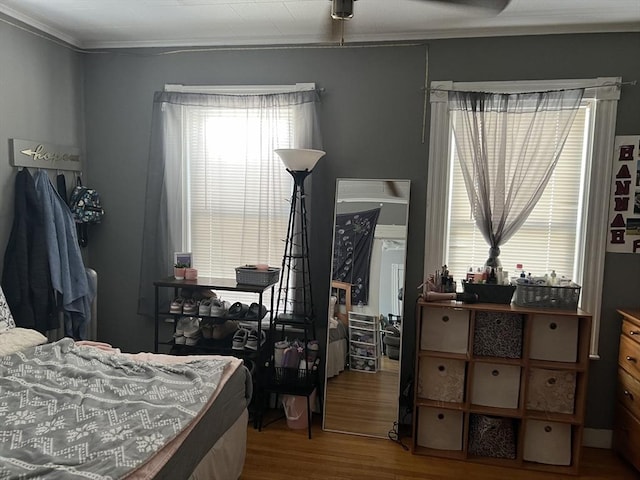 bedroom featuring ornamental molding and wood finished floors