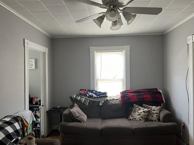 living area featuring ceiling fan and crown molding