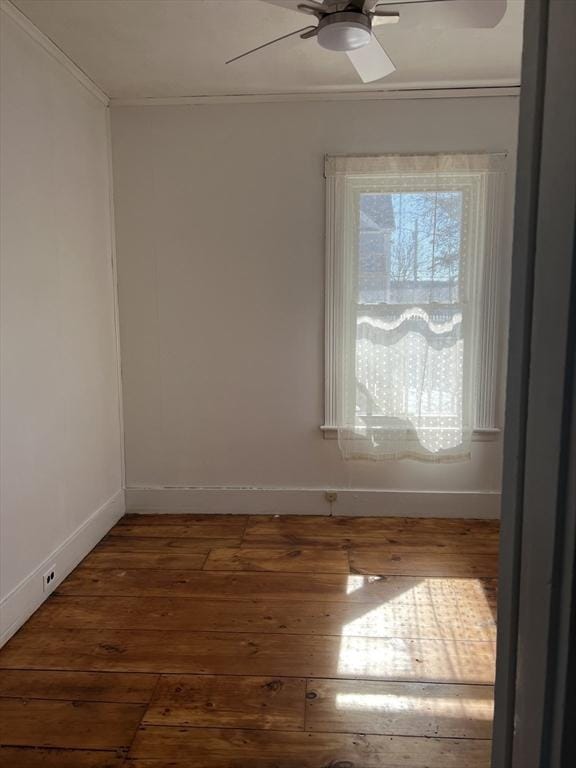 empty room featuring hardwood / wood-style flooring, baseboards, and a ceiling fan