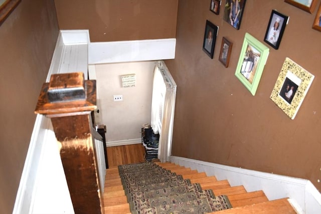 stairway featuring hardwood / wood-style flooring and a fireplace