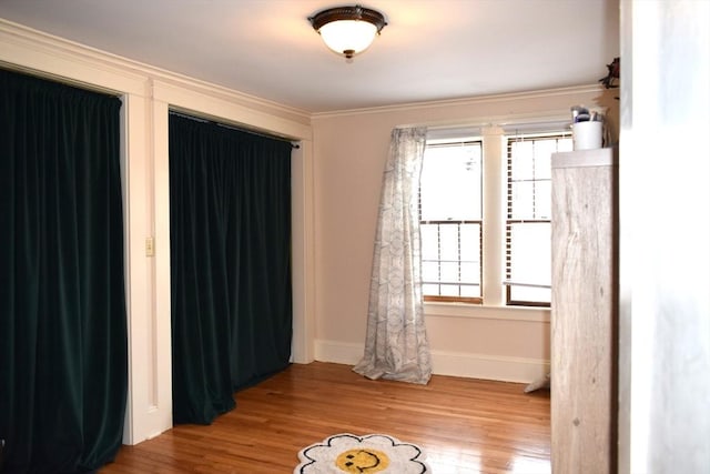 unfurnished bedroom with hardwood / wood-style flooring and ornamental molding