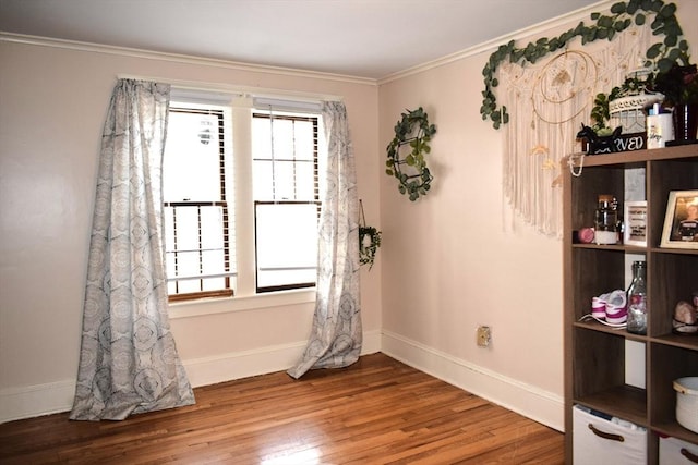 unfurnished room with crown molding, wood-type flooring, and a healthy amount of sunlight