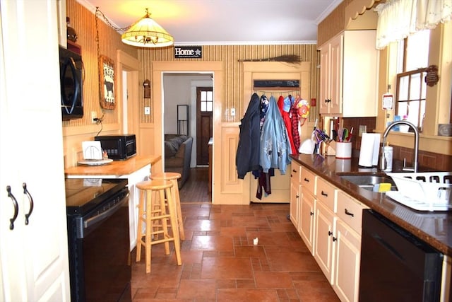 kitchen featuring crown molding, sink, a wealth of natural light, and black appliances