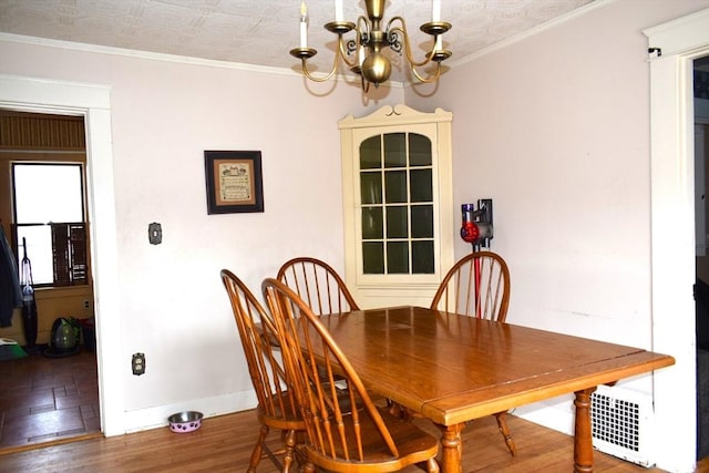 dining area featuring crown molding, dark hardwood / wood-style flooring, and a chandelier