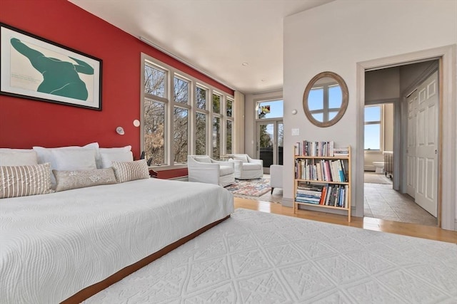 bedroom with an accent wall, wood finished floors, and ensuite bathroom