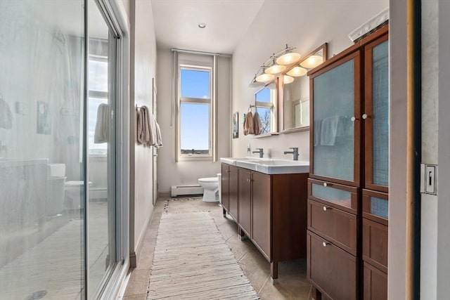 bathroom with a baseboard radiator, toilet, vanity, tile patterned floors, and a stall shower