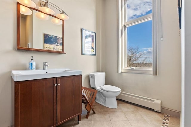 bathroom with a baseboard radiator, toilet, vanity, tile patterned flooring, and baseboards