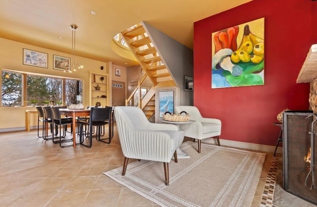 living area with stairway, tile patterned flooring, and baseboards