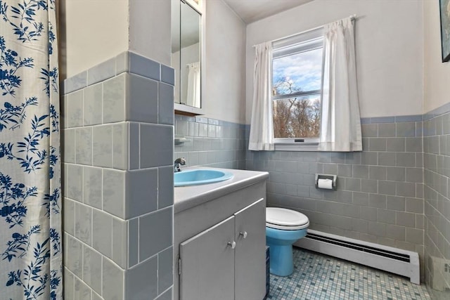 full bathroom with toilet, a baseboard heating unit, vanity, tile walls, and tile patterned floors