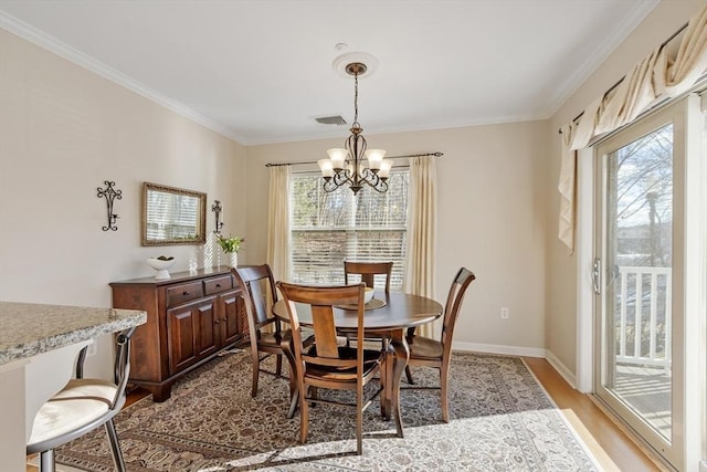 dining space featuring ornamental molding, a healthy amount of sunlight, a notable chandelier, and light hardwood / wood-style flooring