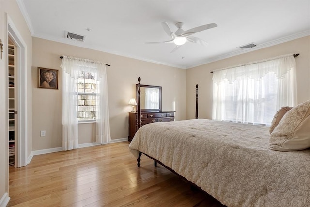 bedroom with ornamental molding, ceiling fan, and light wood-type flooring