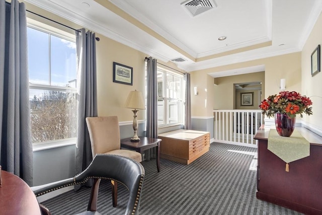 interior space with ornamental molding, a raised ceiling, and dark carpet