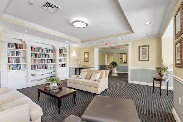 carpeted living room featuring crown molding, built in features, and a tray ceiling