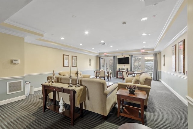 carpeted living room with ornamental molding and a raised ceiling