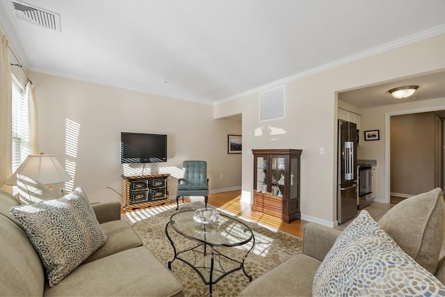 living room with ornamental molding and light hardwood / wood-style flooring