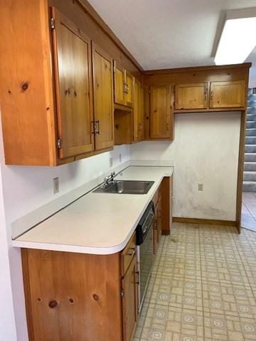 12 Perkins Ct Unit 12, Haverhill, MA 01832 - kitchen with brown cabinetry, baseboards, light countertops, a sink, and dishwasher