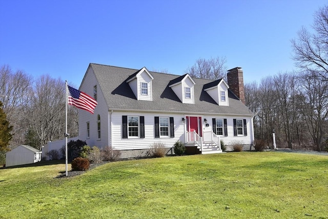 cape cod-style house featuring a chimney, a front lawn, and a shingled roof