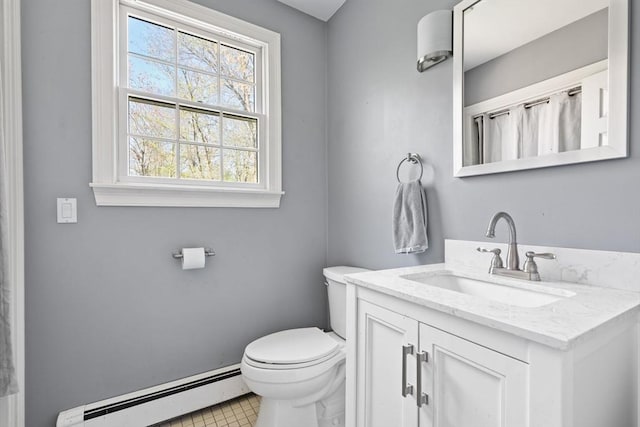 bathroom featuring baseboard heating, vanity, baseboards, tile patterned floors, and toilet