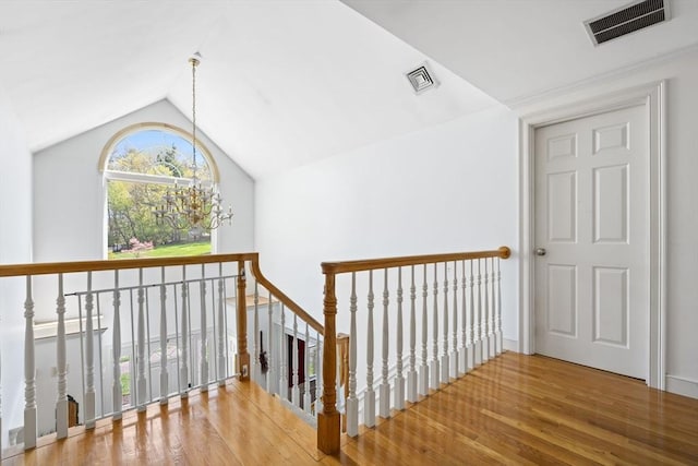 interior space featuring an upstairs landing, wood finished floors, and visible vents