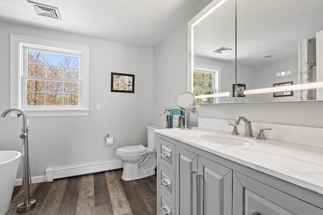 bathroom featuring visible vents, toilet, baseboards, wood finished floors, and a baseboard heating unit