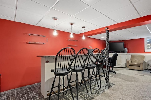 bar featuring pendant lighting, a dry bar, and a paneled ceiling