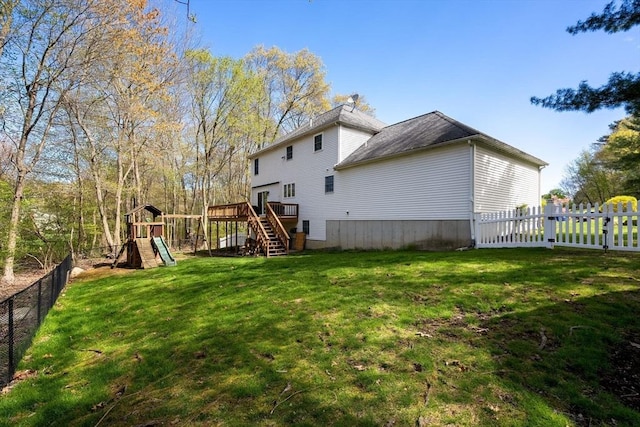 back of house with a deck, stairway, a fenced backyard, a playground, and a yard